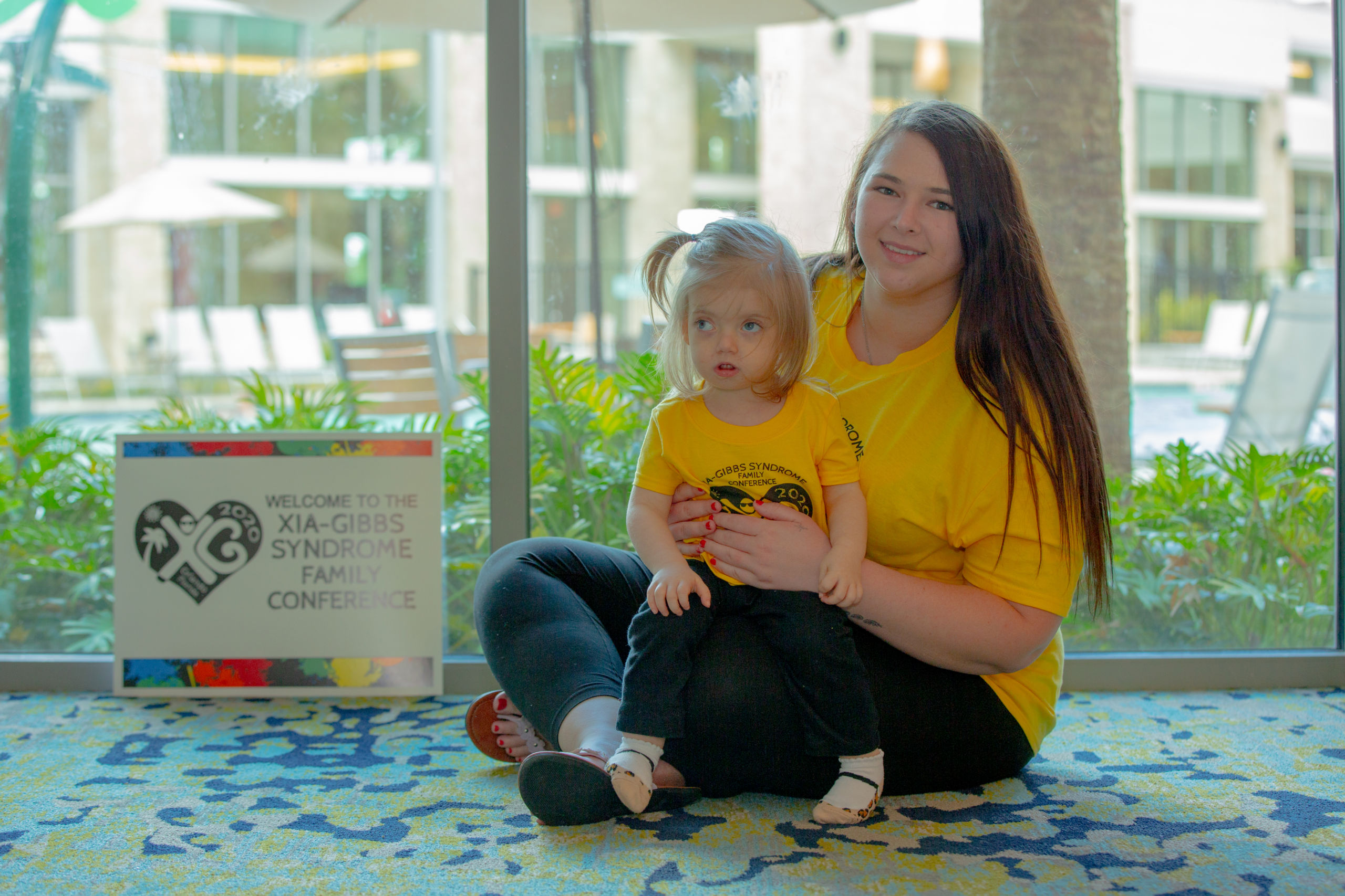 Young woman and her little sister who has Xia-Gibbs syndrome